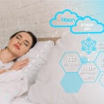 A woman is sleeping in bed with a cloud in the background.