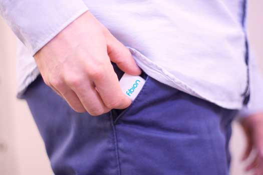 A man is holding a small device in his pocket.
