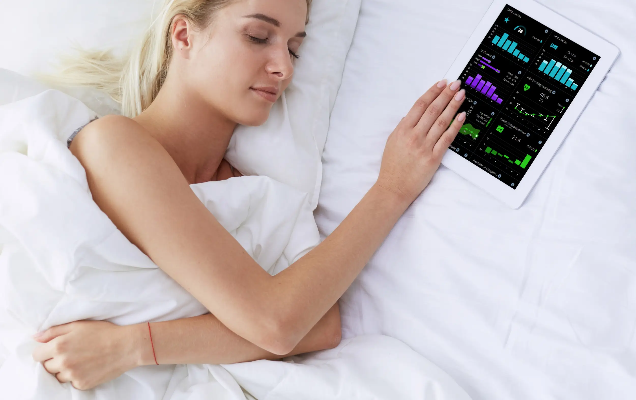 A woman sleeping in bed with an ipad in her hand.