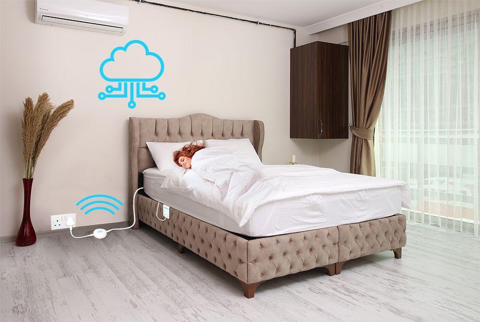 A person sleeps on a bed in a modern bedroom with a large window. The bed, equipped with Emfit technology, is connected to cloud technology and Wi-Fi, as indicated by the icons near it.