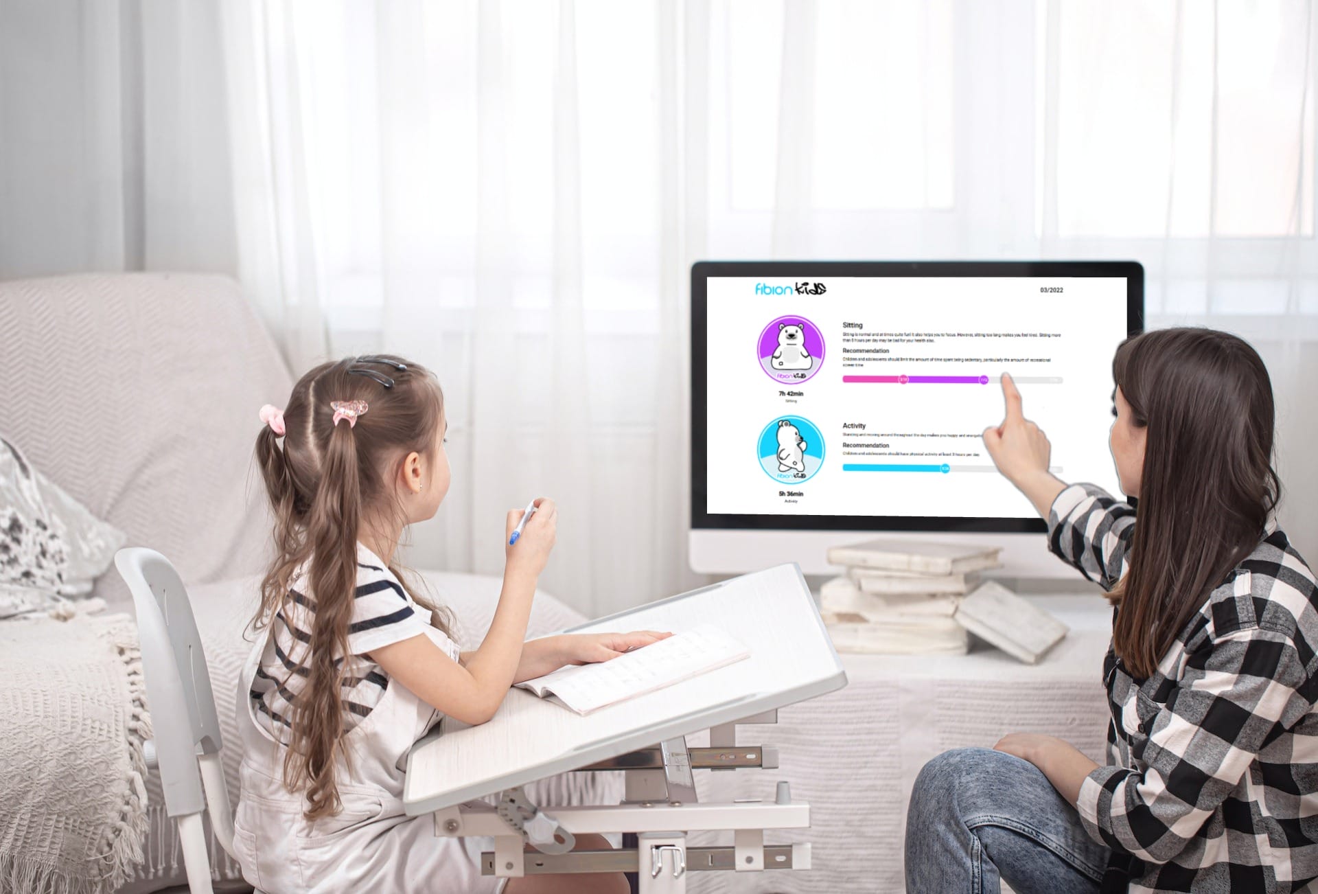 Two children engaging with the Fibion Kids educational program on a computer screen in a bright room.