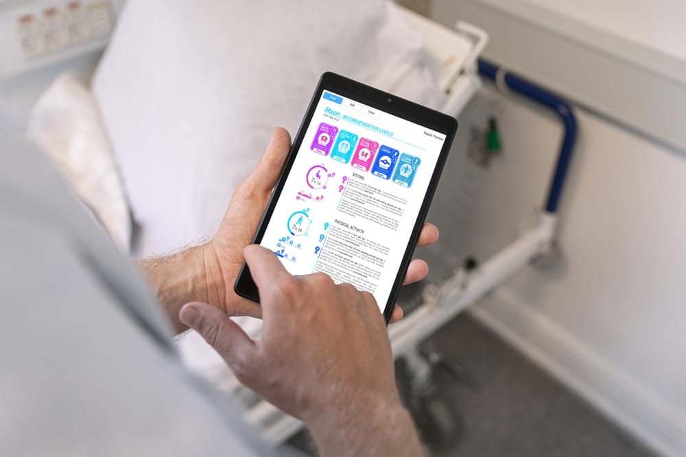 A healthcare professional holding a tablet displaying medical reports and apps, standing in a clinical setting.