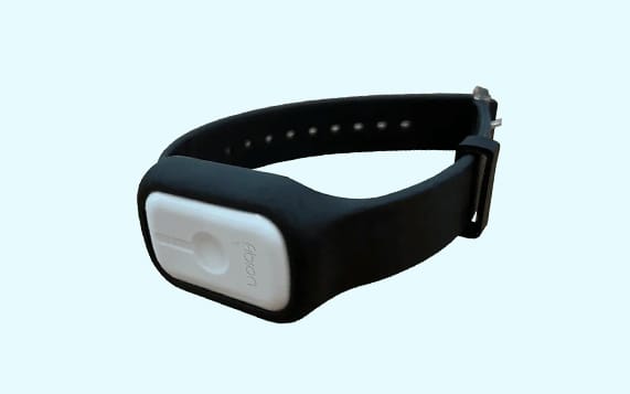 A sleek, black wearable strap with a white, rectangular device affixed. It features a single button and the text "A10N" prominently displayed. The background is light blue.