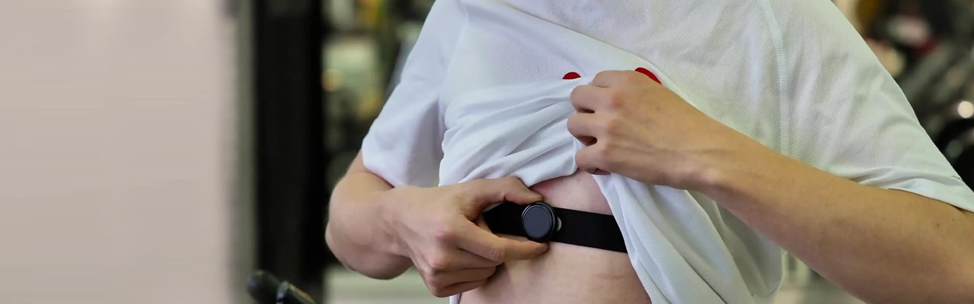 Person adjusting a Flash chest strap heart rate monitor for optimal HRV tracking under a lifted white shirt.