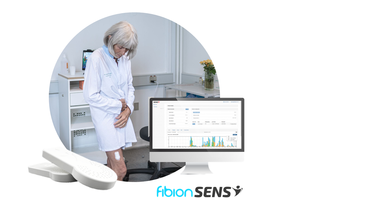 Woman stands in a room wearing a medical device on her thigh, with the Albion SENS logo visible. Nearby, a computer monitor displays health data charts from multi-site research devices, highlighting their essential features in monitoring wellness.