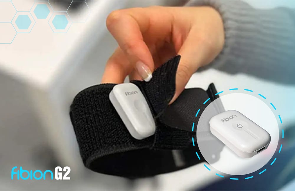 Hand holding a black strap with a small white device attached, labeled Fibion G2, and an enlarged inset of the device.