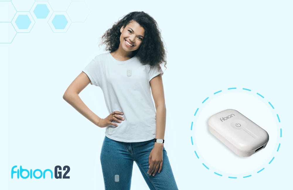 Smiling person wearing a white t-shirt and jeans, with a small electronic device on the shirt. The text reads "Fibion G2." There's a close-up of the device on the right.